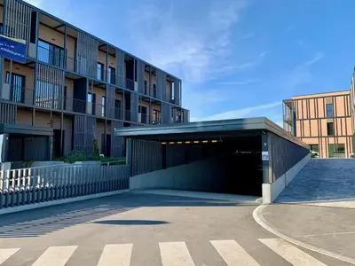a building with a parking garage in front of it at DR7 Bled in Bled