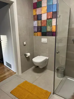 a bathroom with a toilet and a glass shower at DR7 Bled in Bled