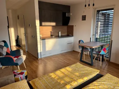 a kitchen and a living room with a table and chairs at DR7 Bled in Bled