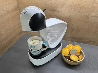 a coffee maker is pouring coffee into a cup at DR7 Bled in Bled