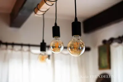 a group of lights hanging from a ceiling at Pet & Family Friendly House Viktorija - house near Golica with Triglav view in Jesenice