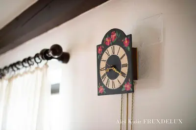 a clock hanging on a wall in a room at Pet & Family Friendly House Viktorija - house near Golica with Triglav view in Jesenice