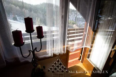 a lamp in front of a window with two candles at Pet & Family Friendly House Viktorija - house near Golica with Triglav view in Jesenice