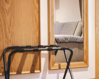 a mirror and a chair in front of a mirror at Guest House Pri Cesarju in Kamnik