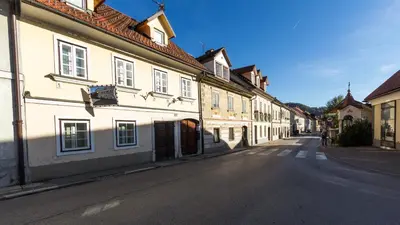 an empty street in a town with white buildings at Guest House Pri Cesarju in Kamnik