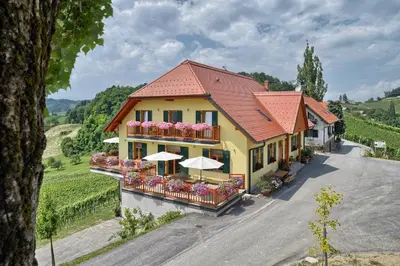an aerial view of a building with flowers and umbrellas at Farm Stay Jarc Vineyard in Svečina