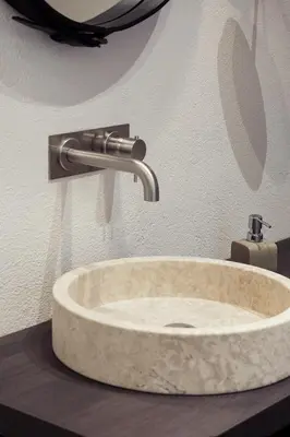 a stone sink in a bathroom with a faucet at Kollmann Rooms and Apartments in Ljubljana