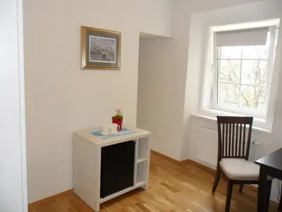 a room with a table and a chair and a window at Kollmann Rooms and Apartments in Ljubljana