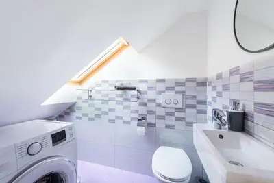 a bathroom with a washer and a toilet and a sink at Kollmann Rooms and Apartments in Ljubljana