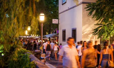 a crowd of people walking down a street at night at Kollmann Rooms and Apartments in Ljubljana