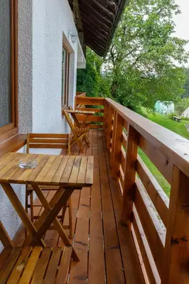 a wooden deck with a wooden table and bench at Bed&Breakfast Anž'k in Bled