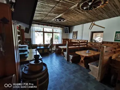 a dining room with wooden tables and benches and a window at Bed&Breakfast Anž'k in Bled