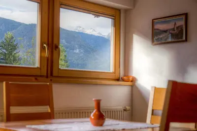 a vase sitting on a table in front of a window at Apartments Brina in Bohinj