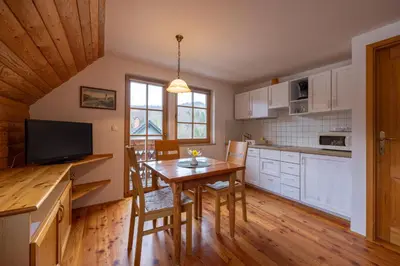 a kitchen with a wooden table and a dining room at Apartments Brina in Bohinj
