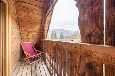 a pink chair sitting on a porch with a window at Apartments Brina in Bohinj