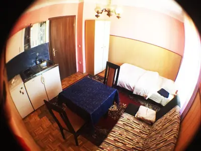 a room with a table and a bed with a blue table sidx sidx at Guest House Pikapolonca in Maribor