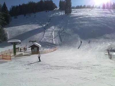 a group of people skiing down a snow covered slope at Guest House Pikapolonca in Maribor