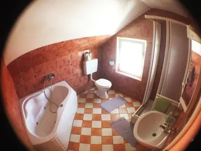 a bathroom with a tub and a toilet and a sink at Guest House Pikapolonca in Maribor
