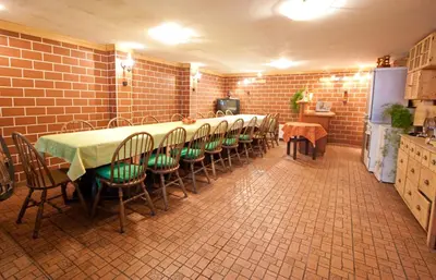a room with a long table and chairs in a kitchen at Guest House Pikapolonca in Maribor