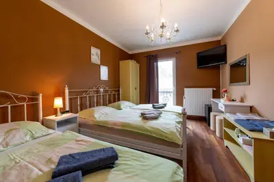 a bedroom with two beds and a chandelier at Rooms Herman in Pivka