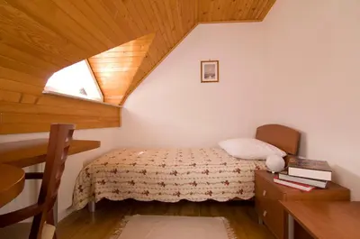 a small bedroom with a bed and a window at B&B Na Kluk in Idrija