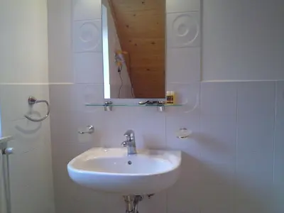 a white bathroom with a sink and a mirror at B&B Na Kluk in Idrija