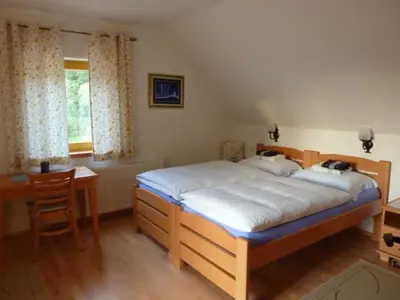 a bedroom with a bed and a table and a desk at Farm Stay Rotovnik - Plesnik in Slovenj Gradec
