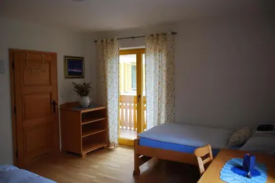 a bedroom with a bed and a door and a table at Farm Stay Rotovnik - Plesnik in Slovenj Gradec