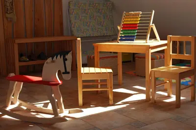 a room with wooden chairs and a rocking horse at Farm Stay Rotovnik - Plesnik in Slovenj Gradec