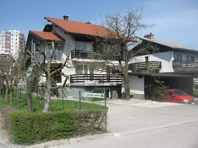 a large white building with a red roof at Rooms and Apartment Na poljani in Škofja Loka