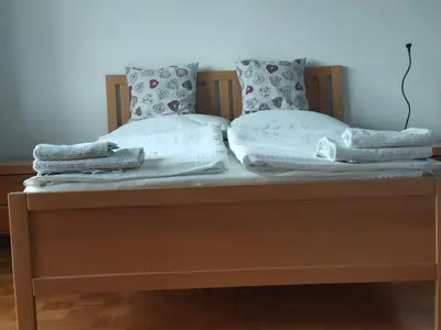 a bed with two pillows and towels on it at Rooms and Apartment Na poljani in Škofja Loka
