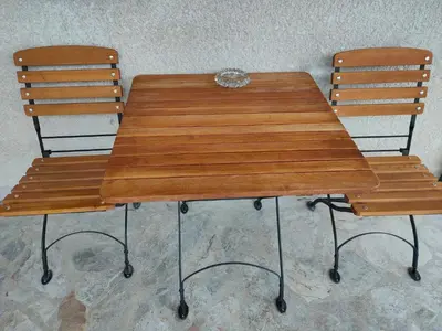a wooden table and two chairs sitting next to at Rooms and Apartment Na poljani in Škofja Loka