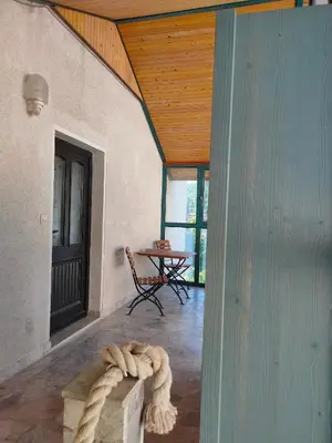 a room with a wooden ceiling and a table with a rope at Rooms and Apartment Na poljani in Škofja Loka