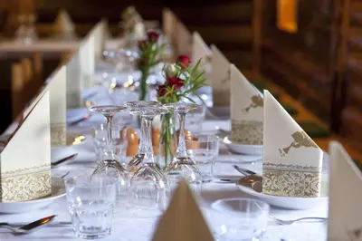a long table with plates and glasses and flowers at Guesthouse Pri Zalogarju in Železniki