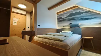a bedroom with a bed with a painting on the wall at Guesthouse Pri Zalogarju in Železniki