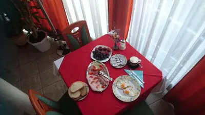 a red table with plates of food on it at Penzion Zeleni Kakadu in Maribor