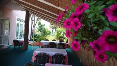 a restaurant with tables and pink flowers on the wall at Penzion Zeleni Kakadu in Maribor