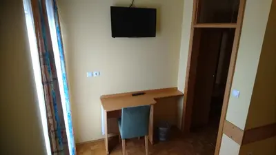 a room with a desk and a television on the wall at Penzion Zeleni Kakadu in Maribor