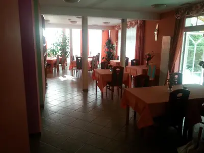 a dining room with tables and chairs in a restaurant at Penzion Zeleni Kakadu in Maribor