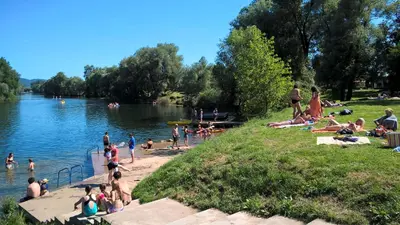 a group of people on a beach near a lake at Holiday resort Bela krajina - Glamping and Mobile Homes in Metlika