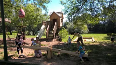 a group of people playing in a playground at Holiday resort Bela krajina - Glamping and Mobile Homes in Metlika