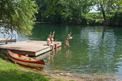 a group of children playing in the water at a dock at Holiday resort Bela krajina - Glamping and Mobile Homes in Metlika