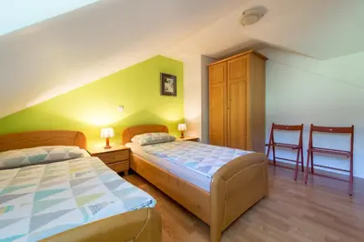 a bedroom with two beds and two chairs at Apartments Jaka in Dolenjske Toplice
