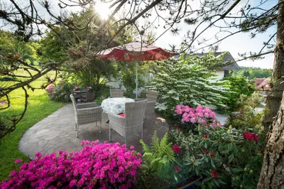 a patio with a table and chairs and flowers at Apartments Jaka in Dolenjske Toplice