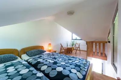 a bedroom with a bed with a blue and white comforter at Apartments Jaka in Dolenjske Toplice