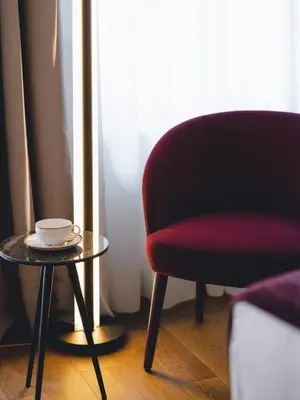 a red chair and a table with a cup on it at Hotel Heritage in Ljubljana