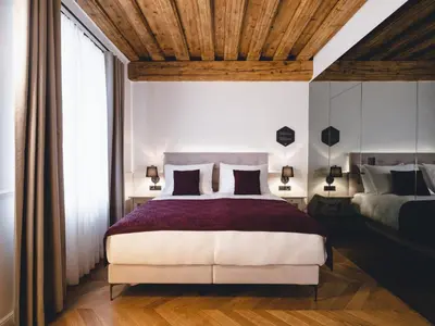 a bedroom with a large bed and a wooden ceiling at Hotel Heritage in Ljubljana