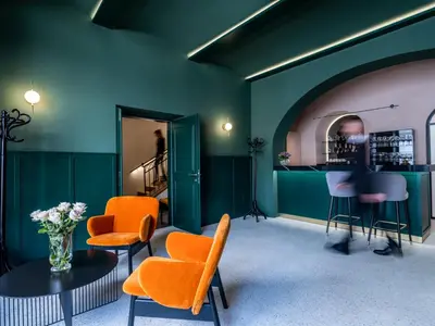 a room with green walls and orange chairs and a table at Hotel Heritage in Ljubljana