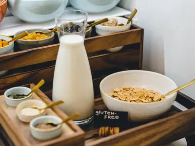 a shelf with a bowl of cereal and a bottle of milk at Hotel Heritage in Ljubljana