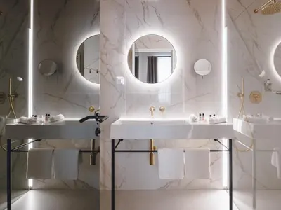 a bathroom with two sinks and a mirror at Hotel Heritage in Ljubljana